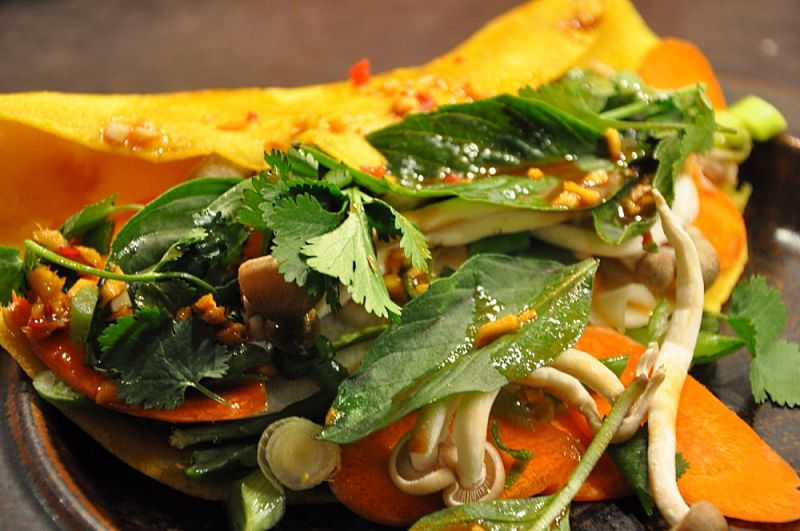 bahn xeo pancakes are usually served with fresh herbs, bean sprouts, Asian salad greens and a delightful homemade sauce.