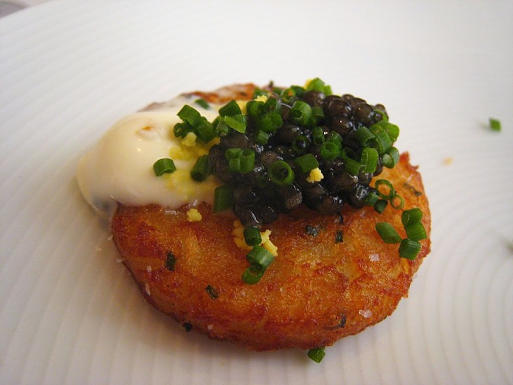 Caviar on a potato cake with egg and cheese