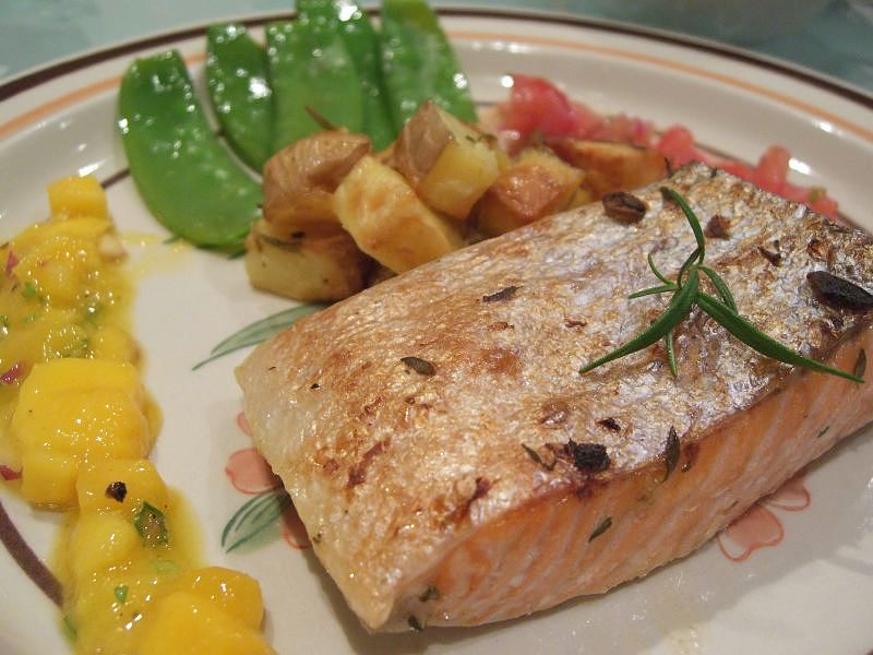 A lovely piece of grilled salmon with skin on. Just a delicate sprinkling of herbs and seasonings. The skin can be easily removed when the fish is served or being eaten. The skin helps to keep the fish intact while it is being cooked.