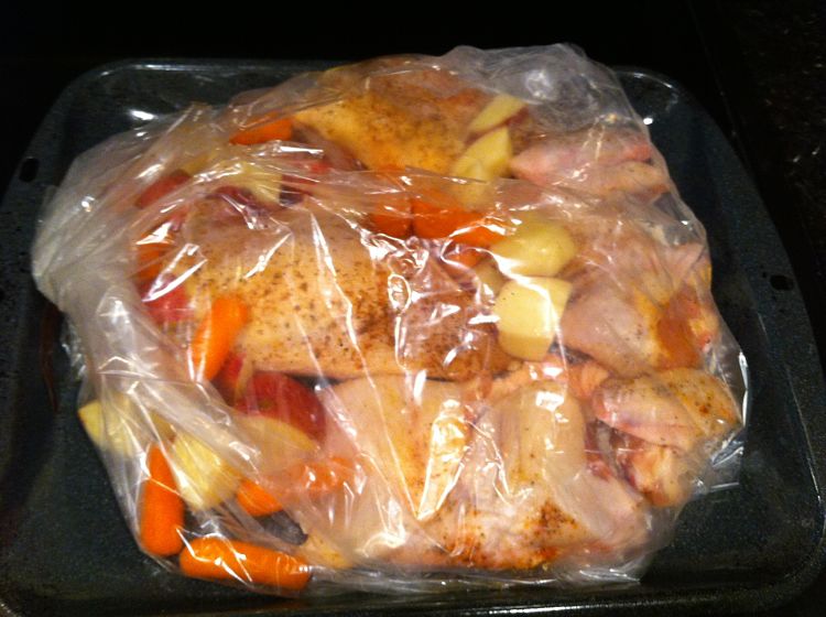 A chicken and vegetable meal cooked in a large heavy duty oven bag