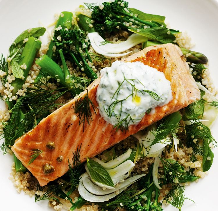 Grilled salmon served over a bed of couscous, greens and fresh herbs