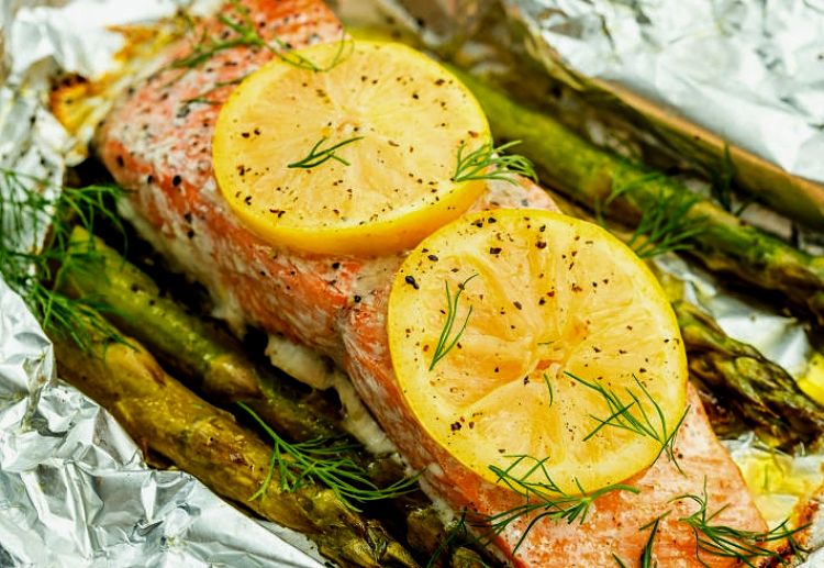 Lemon slices, a lemon sauce and asparagus spears added to the delights of pan-fried salmon fillets