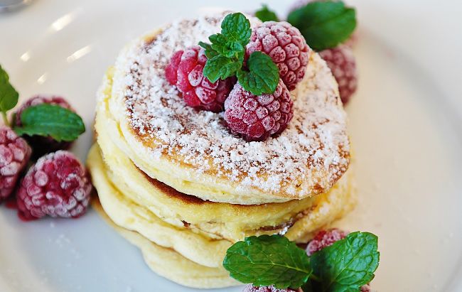 Pancakes with raspberries, mint and diusted with castor sugar