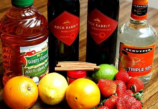 Ingredients for making wine and liqueur based Sangria with oranges, strawberry lime and spices. Delicious and so refreshing.
