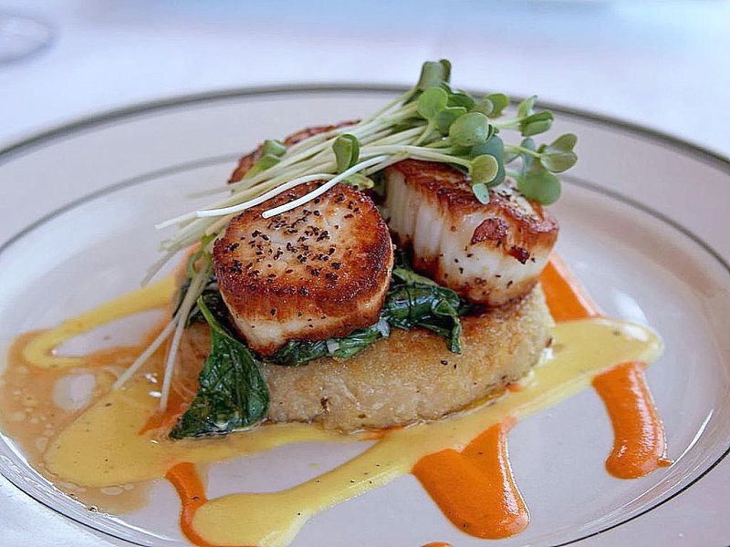 Seared sea scallops is a delightful and delicate dish that goes well with spinach and herbs, and a delicate wine sauce