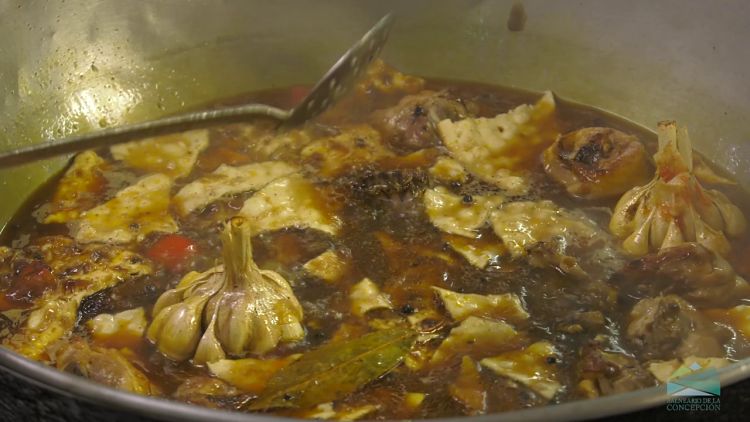 Rich and steamy meat stew with vegetables and garlic gloves.