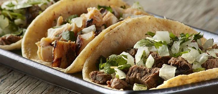 Beautiful homemade gourmet tacos with slow cooked beef squares, lettuce and salsa