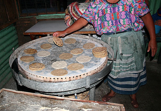 Cooking tortillas on a large comal in Guatemala.
